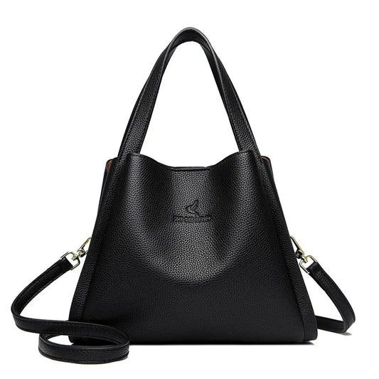 Black leather handbag with a strap on a white background