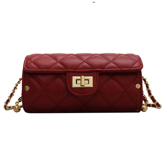 Red quilted handbag with gold chain strap on a white background