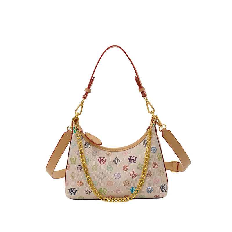 Niras essentials hobo shoulder bag in beige canvas with a multicolor monogram pattern, brown leather trim, and gold-tone chain and strap details, shown on a plain white background.